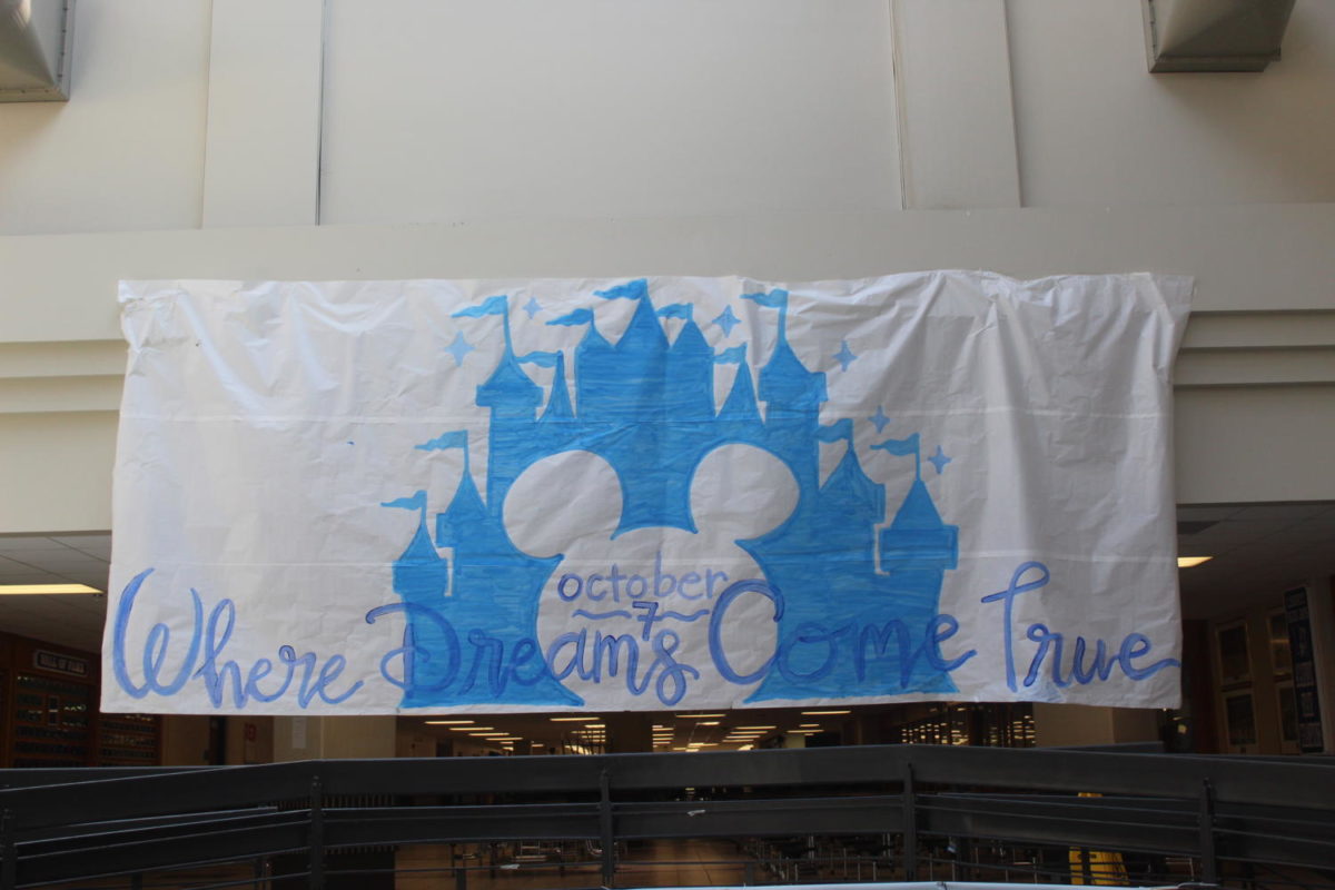 StuCo+members+advertise+the+Disney+themed+homecoming+with+a+banner+in+the+atrium%2C+promoting+the+dance+on+October+7.+Photo+by+McKenna+Hegger