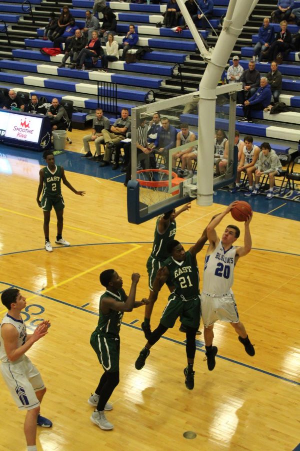 Junior Kellen Goodwin scores against a player from Kansas City East High School. Photo by Kylee Williams.